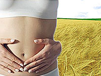 mulhe com a m&atilde;o no abdom&ecirc;n e trigo no fundo 